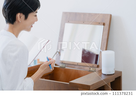 一位女士在她房間的筆記本上寫下她的計劃 111378231