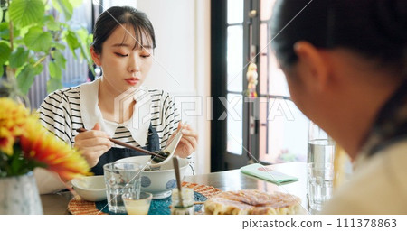 Japanese woman, eating and food in restaurant, chopsticks and hungry with plate for nutrition. Girl, people and bowl for health, wellness and diet with choice at cafeteria, diner and brunch in Tokyo 111378863