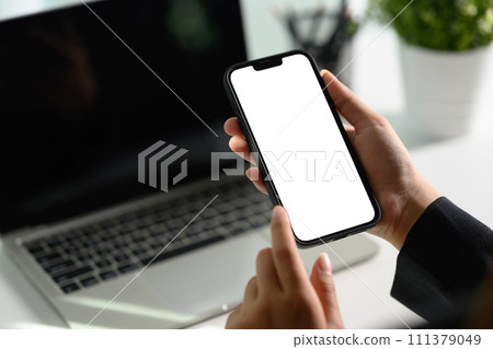 Unrecognizable businesswoman using smartphone at office desk0 Empty screen for your text message Unrecognizable businesswoman using smartphone at office desk0 Empty screen for your text message 111379049