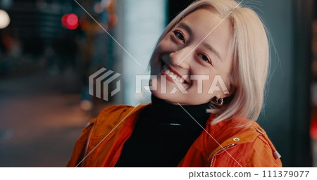 Woman, portrait and smile in city at night on Japanese street for explore, vacation or bokeh. Female person, face and happy in urban town for party adventure for tourism travel, fashion or confidence 111379077