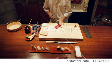 Hands, cooking and sushi with chef in restaurant for traditional Japanese cuisine closeup from above. Kitchen, seafood dish preparation and person working with gourmet meal recipe ingredients 111379085
