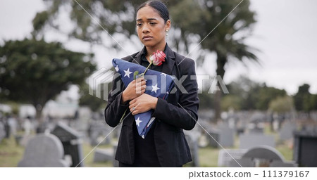 Funeral, rose and american flag with a woman at a cemetery in mourning at a memorial service. Sad, usa and an army wife as the widow of a patriot in a graveyard, feeling pain of death, loss or grief 111379167