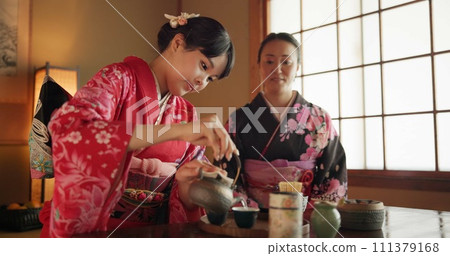 Japanese, friends or kimono for tea ceremony in Chashitsu with peace or custom tradition. Women, temae or vintage style dress or conversation with culture, fashion or honor with antique crockery Japanese, friends or kimono for tea ceremony in Chashitsu with peace or custom tradition. Women, temae or vintage style dress or conversation with culture, fashion or honor with antique crockery 111379168