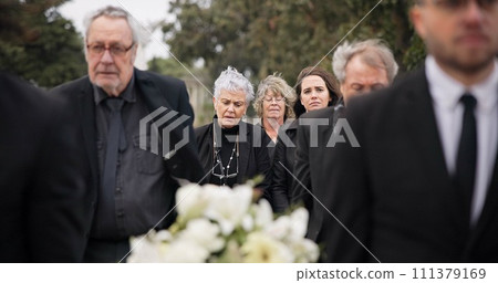 Pallbearers, men and walking with coffin in funeral, ceremony or mourning event at graveyard with sad, grief and flowers. People, support and walk with family in memorial service together with casket Pallbearers, men and walking with coffin in funeral, ceremony or mourning event at graveyard with sad, grief and flowers. People, support and walk with family in memorial service together with casket 111379169
