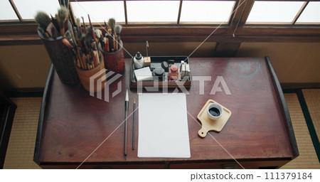 Art, paint brush and painting tool for painter, calligraphy and drawing at a desk for creative work. Sketch paper, Japanese sumi and home studio with ink pot and document for creativity above 111379184