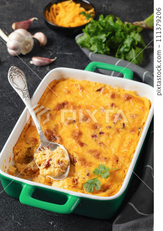 cheesy smoked sausage grits bake in ceramic dish 111379206