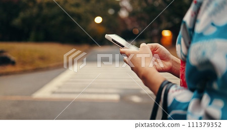City, phone and hands of Japanese person in street for online networking, website and social media. Travel, walking and closeup of typing on smartphone with traditional fashion, culture and kimono 111379352
