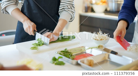 Chef hands, knife and spring onion for cooking, chopping and prepare ingredients for catering services. Person, cutting vegetables and food for diet, nutrition and fine dining at restaurant in Tokyo Chef hands, knife and spring onion for cooking, chopping and prepare ingredients for catering services. Person, cutting vegetables and food for diet, nutrition and fine dining at restaurant in Tokyo 111379356