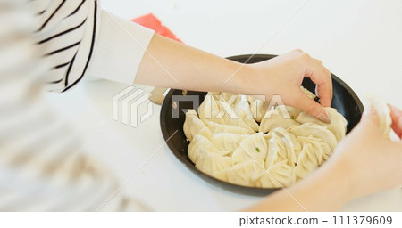 Japan, hands and dumplings on table for dinner, brunch and traditional meal in restaurant or cafe. Culture, gyozo and asian cuisine for nutrition, healthy diet and lunch with preparation or pastry Japan, hands and dumplings on table for dinner, brunch and traditional meal in restaurant or cafe. Culture, gyozo and asian cuisine for nutrition, healthy diet and lunch with preparation or pastry 111379609