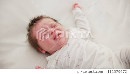 Newborn, face and sleeping with dream on bed in nursery for relaxing or resting with child development. Baby, tired and waking up in bedroom of house with calm, relax and cute infant in family home 111379672