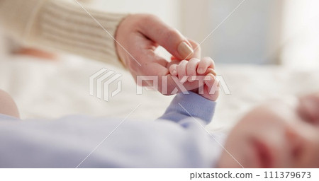 Parents, family and holding hands with baby on bed for bonding, love and relationship with infant. Adorable, cute and closeup of mom with hand of newborn for support, wellness and protection at home 111379673