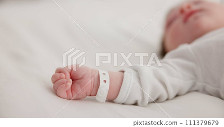 Baby, new born and hand with bracelet on bed for care, trust or support in hospital for birth. Infant, love and hope with child development for future growth in family home, protection and security 111379679