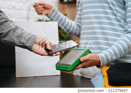 Man customer paying with smartphone in store 111379687
