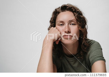 Displeased tired sleepy curly woman, propping his cheek, looking bored Displeased tired sleepy curly woman, propping his cheek, looking bored 111379693