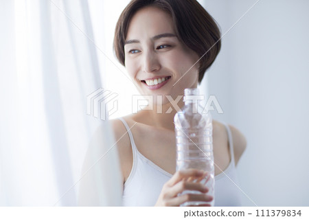 Young woman drinking water and relaxing 111379834