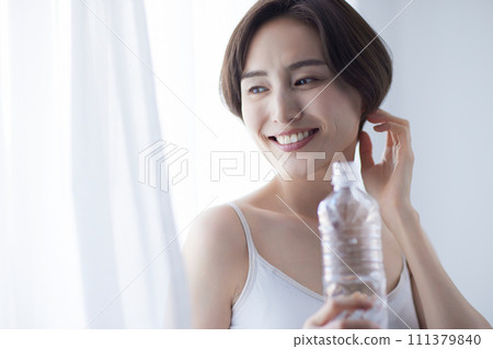 Young woman drinking water and relaxing Young woman drinking water and relaxing 111379840