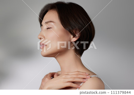 Skin care image of a young woman photographed against a background of light and shadow 111379844