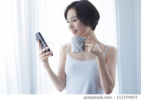 Young woman relaxing with a smartphone 111379955