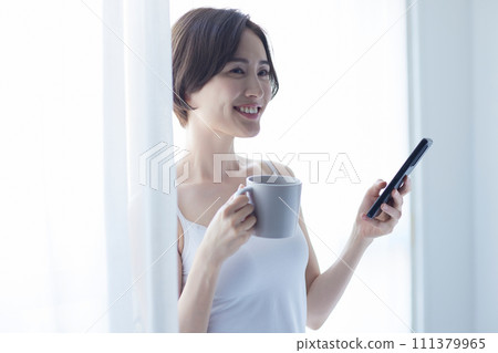 年輕女子用智慧型手機放鬆 111379965