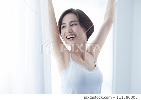Young woman wearing a camisole relaxing Young woman wearing a camisole relaxing 111380005