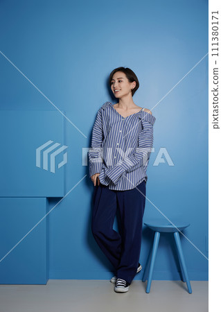 Portrait of a young woman in casual clothes against blue background 111380171