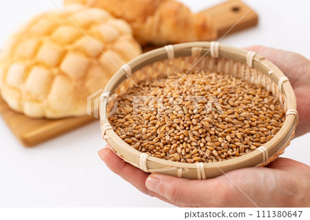 Woman's hand holding wheat and bread Woman's hand holding wheat and bread 111380647
