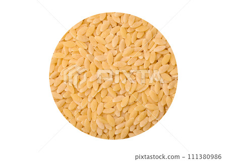 Raw risoni pasta made from durum wheat on a dark concrete background Raw risoni pasta made from durum wheat on a dark concrete background 111380986