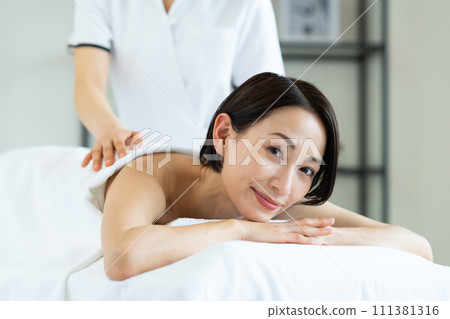 A middle-aged woman receiving beauty treatment 111381316