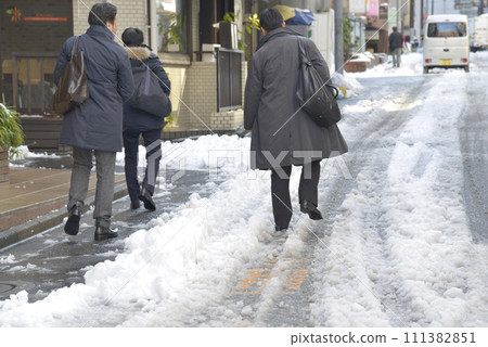People walking on a snowy road People walking on a snowy road 111382851