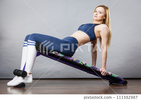 Woman training on bench for sit ups Woman training on bench for sit ups 111382987
