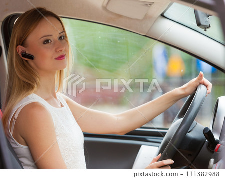 woman driving car with headset woman driving car with headset 111382988