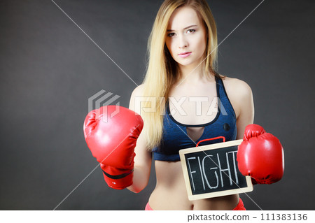 Woman wearing boxing glove holding fight sign 111383136