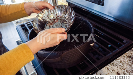 A steamed asparagus dish is being prepared in a modern white kitchen. 111383353