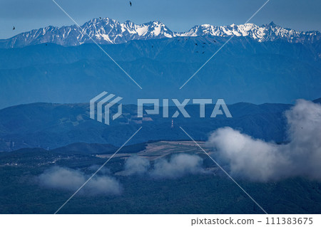 Yatsugatake Mountain Range, Spear of remaining snow seen from Mt. Iodake, Hotaka Mountain Range and flock of house swallows Yatsugatake Mountain Range, Spear of remaining snow seen from Mt. Iodake, Hotaka Mountain Range and flock of house swallows 111383675