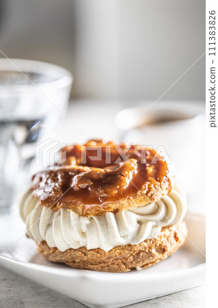 Veternik - sweet donut, typically Slovak caramel sweet cake with cream filling topped with caramel on a plate in a cafe 111383826