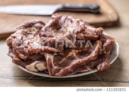 Salted and spiced pork neck ready for baking or grilling. 111383831