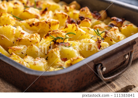 Baked crispy potatoes with rosemary in an old baking dish 111383841