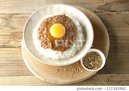 熱 keema 咖哩,配上蛋黃和香料,放在小盤子上 熱 keema 咖哩,配上蛋黃和香料,放在小盤子上 111383992