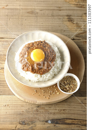 Hot keema curry topped with egg yolk and spices on a small plate 111383997