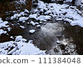 Snow piled river 111384048
