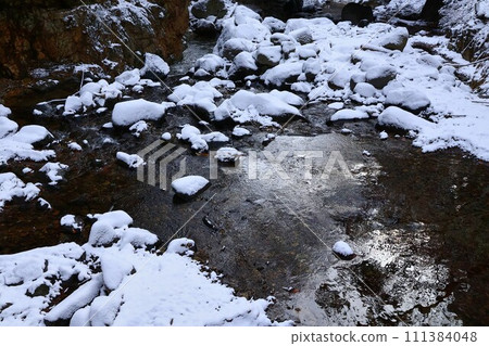 Snow piled river 111384048