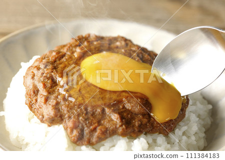 Scene of breaking eggs with a spoon in spicy hot keema curry topped with egg yolk Scene of breaking eggs with a spoon in spicy hot keema curry topped with egg yolk 111384183