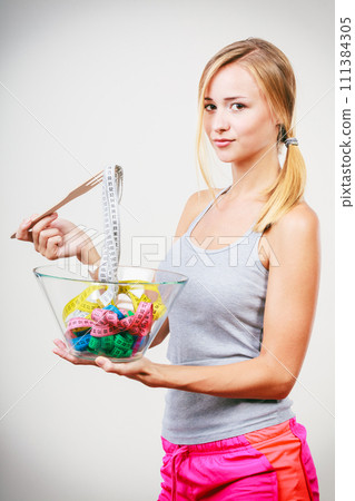 Diet. Girl with colorful measuring tapes in bowl Diet. Girl with colorful measuring tapes in bowl 111384305