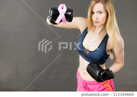 Woman wearing boxing gloves having pink ribbon Woman wearing boxing gloves having pink ribbon 111384669