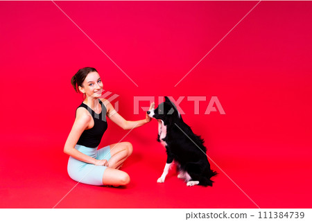 Beautiful sport female with border collie in studio Beautiful sport female with border collie in studio 111384739