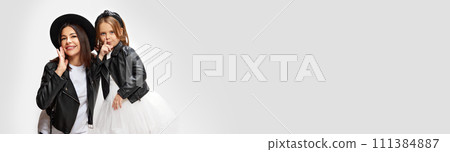 Banner. Mother and daughter holding hands to mouth, smiling against white studio background. Mother's day, Women's day Banner. Mother and daughter holding hands to mouth, smiling against white studio background. Mother's day, Women's day 111384887