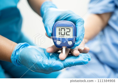 Doctor check diabetes from finger blood sugar level with finger lancet. Doctor check diabetes from finger blood sugar level with finger lancet. 111384908
