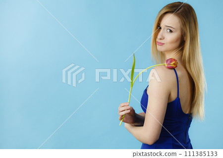 Shot on blue of woman holding tulip 111385133