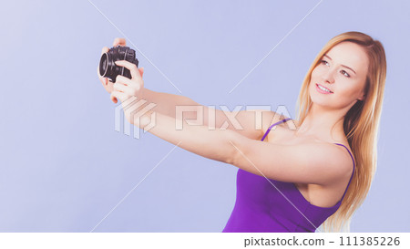 Blonde woman with camera on blue 111385226