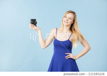 Blonde woman with camera on blue 111385228